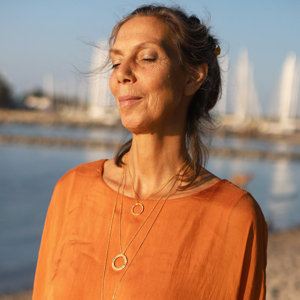 Cora trägt einen Lokah Samastah Mantra Anhänger mini vergoldet von ETERNAL BLISS - Spiritueller Schmuck