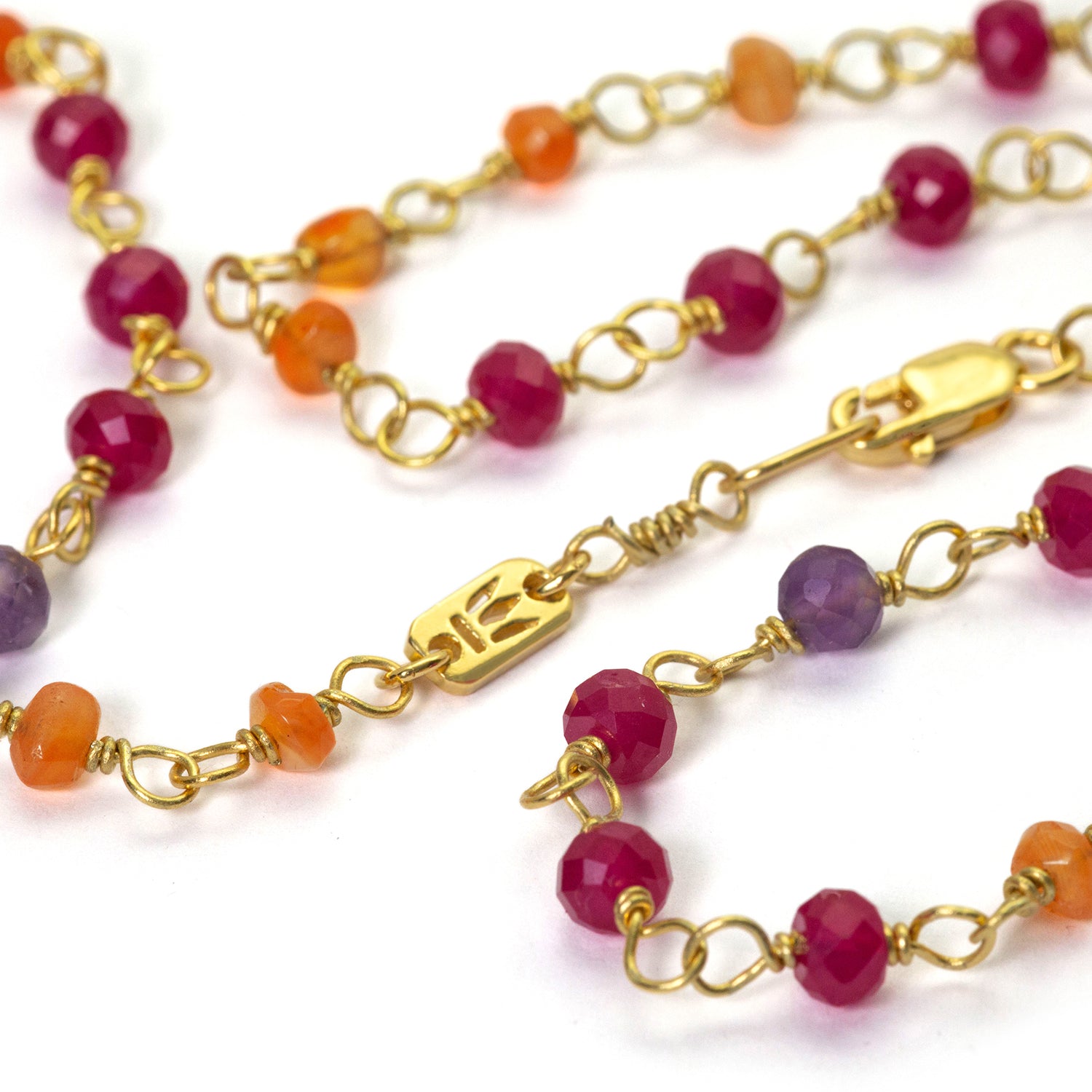 Detail of the powerfully luminous gemstone necklace "Prana" made of high-quality gold-plated sterling silver with rubies, carnelians and amethyst by Eternal Bliss