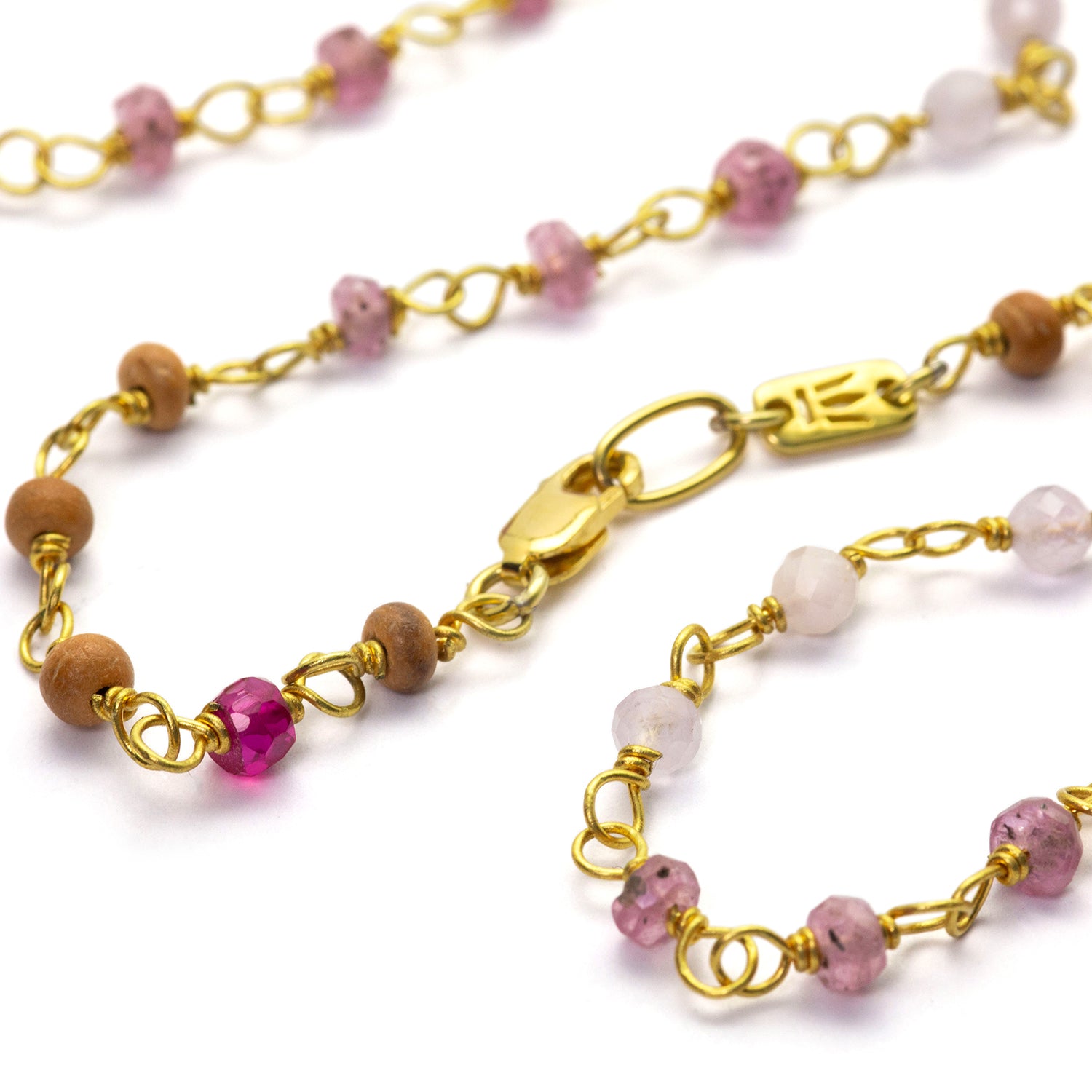 etail of gemstone necklace "Sakura" made of high-quality gold-plated sterling silver with ruby, rock crystal, lavender, and sandalwood by Eternal Bliss