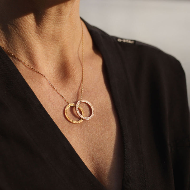 Yoga Teacher Anette Söhnlein trägt einen vergoldeten Lokah-Samastah-Mantra-Anhänger und einen rosévergoldeten von Eternal Bliss