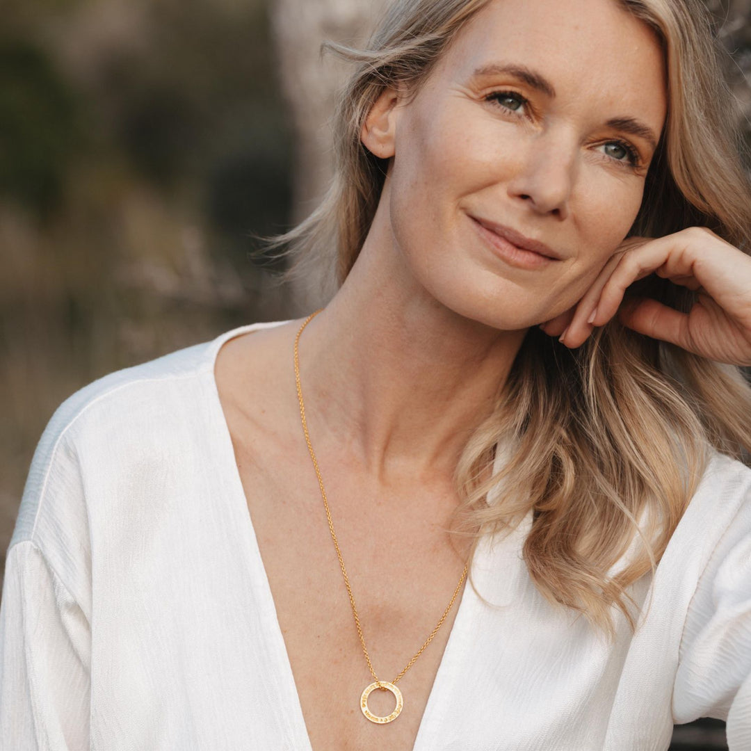 Die Yoga-Lehrerin Annika Isterling trägt einen Gayatri-Mantra-Anhänger-mini aus hochwertig vergoldetem Sterling Silber von ETERNAL BLISS bei ihrer täglichen Praxis