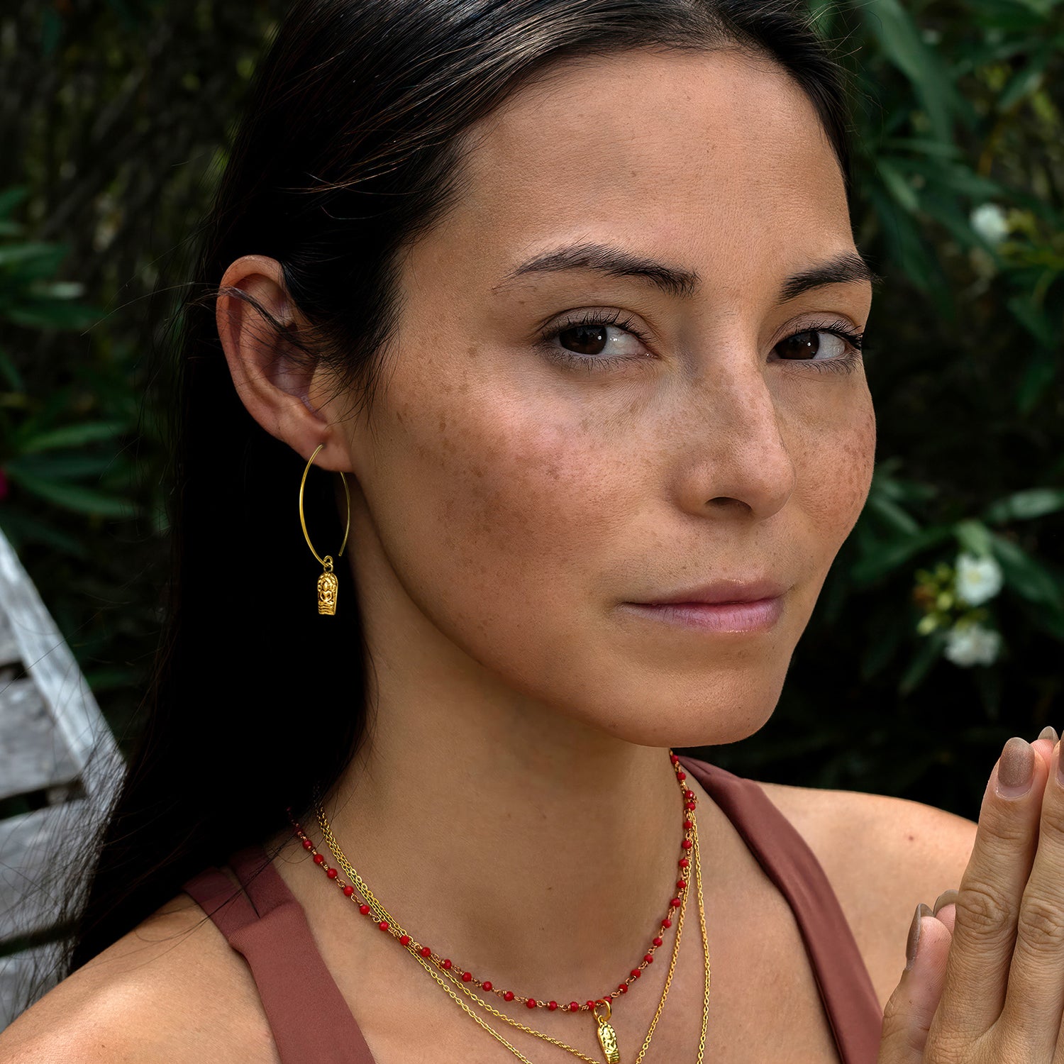 Detailaufnahme: Die Yogalehrerin Steffi trägt Buddha Ohrhaken mini vergoldet aus Sterling Silber zusammen mit anderem hochwertigen Schmuck von ETERNAL BLISS - Spiritueller Schumuck
