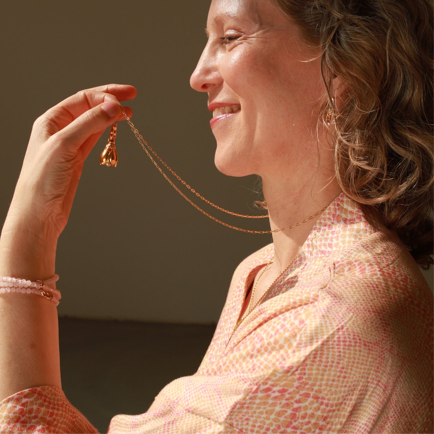 Elena Lustig im Profil, Yoga-Lehrerin in Berlin, mit einem vergoldeten Lotus-Glöckchen-Anhänger von ETERNAL BLISS - Spiritueller Schmuck
