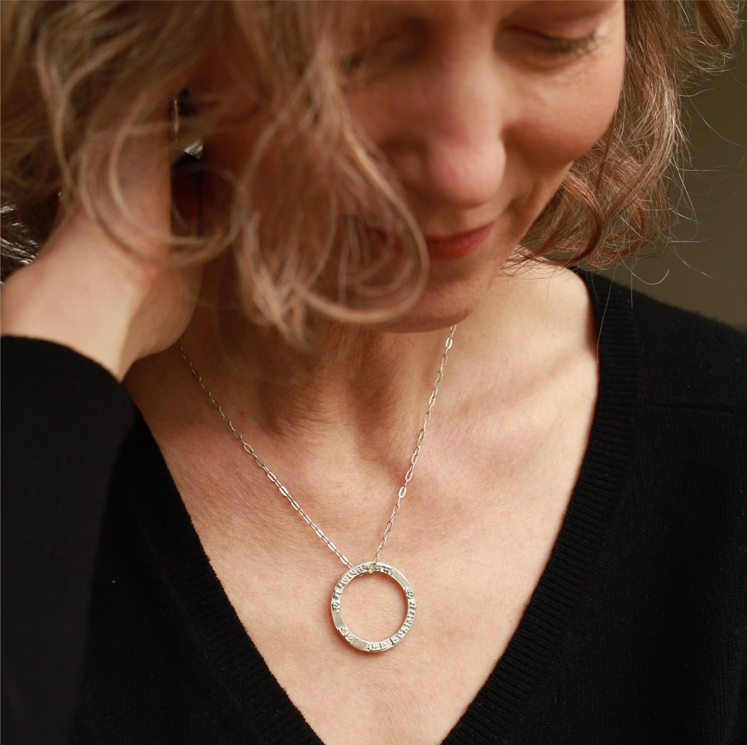 Nahaufnahme von Elena Lustig, die einen Ganesha Mantra Anhänger  aus Sterling Silber von ETERNAL BLISS aus der spirituellen Schmuckkollektion trägt.