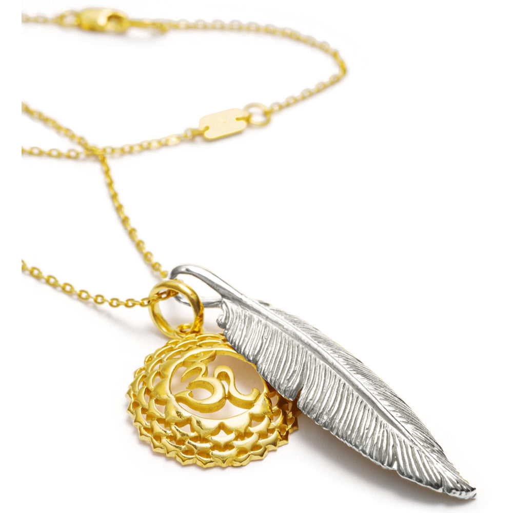 hochwertig kuratierte Halskette bicolor "Leichtigkeit &amp; Weite" zusammengestellt aus einem vergoldeten Kronenchakraanhänger, einem silbernen Federanhänger und einer feinen Ankerkette, liegende Ansicht
